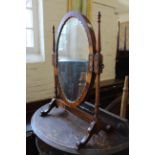 An Edwardian swing toilet mirror with scallop edge oval frame