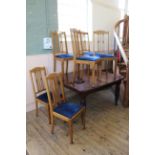 An Edwardian walnut extending dining table with one leaf and a set of six oak dining chairs