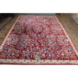 A Chinese red ground wool carpet with blue flowers,