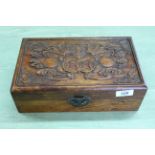 An oriental style carved wood small lidded box decorated with a bat on the lid