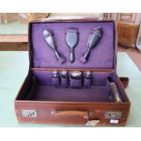 A vintage leather suitcase with various silver topped vanity bottles, hallmarked London 1919, .