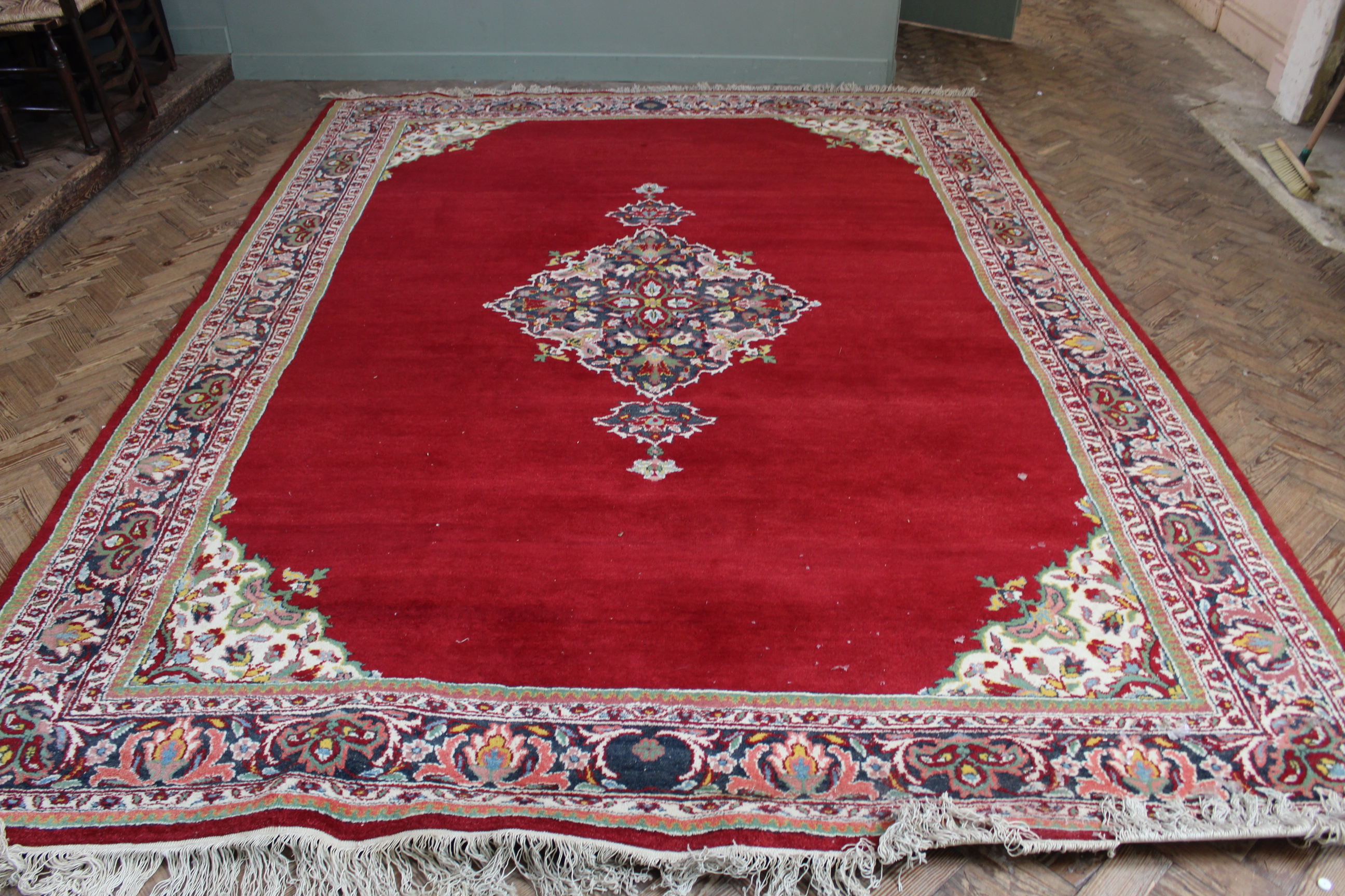 A Chinese red ground wool carpet with central medallion 104" x 146"