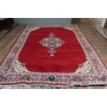 A Chinese red ground wool carpet with central medallion 104" x 146"
