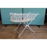 An Edwardian white painted cast metal crib on original casters