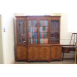 A mid 20th Century walnut veneered breakfront bookcase with built in drinks cabinet below