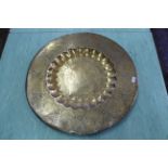 A large circular brass Indian tray with a dished scalloped centre,