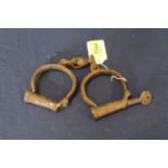 A pair of vintage handcuffs with key