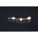 An earring/pendant of drop form set with three large irregular shaped pearls,
