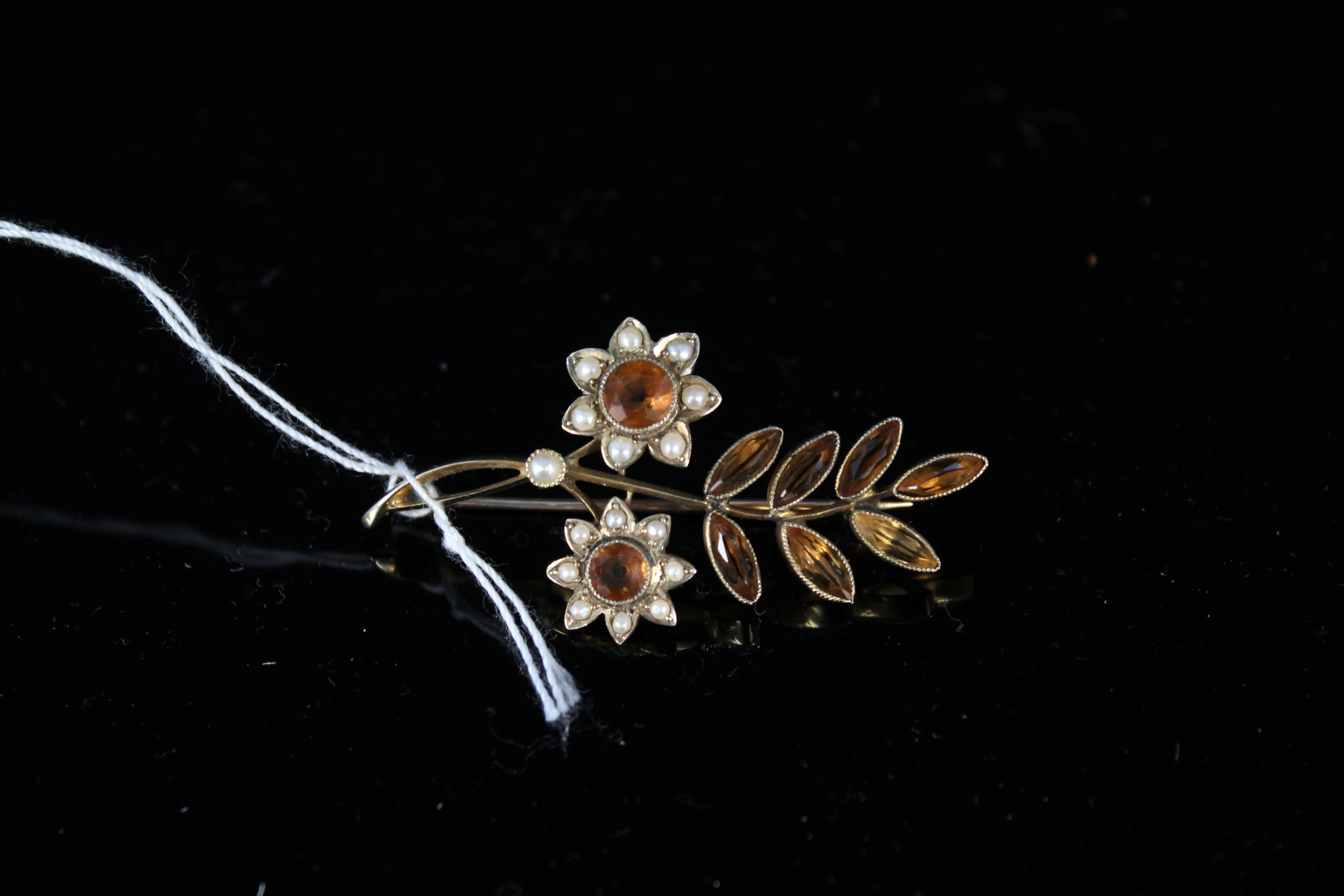 A yellow metal flower spray brooch with seed pearls