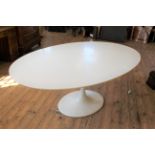 A large white oval tulip table on cast metal base