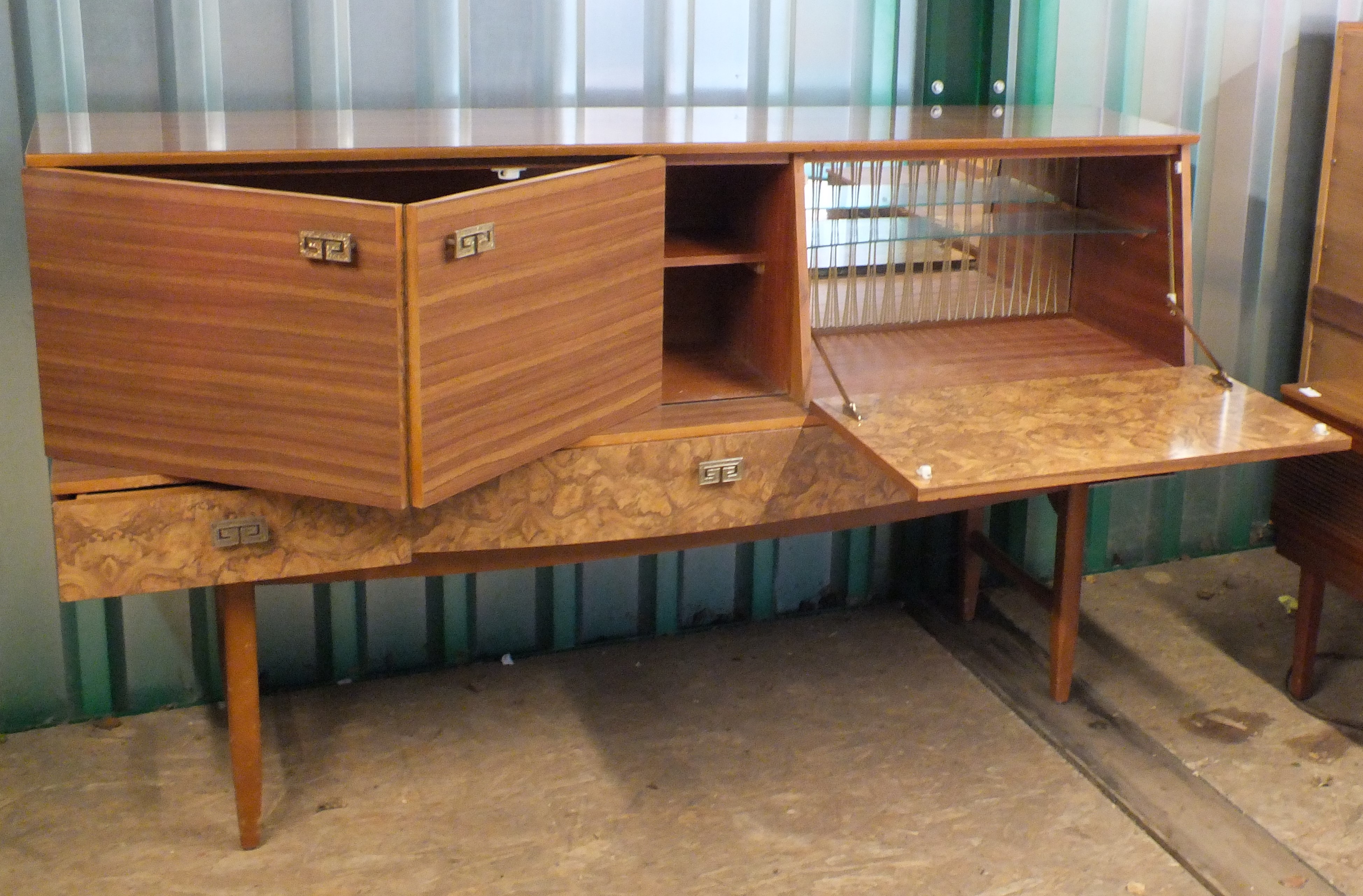 A 1960's sideboard/cocktail cabinet with mock burr walnut panels, folding doors,