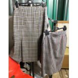 An assortment of vintage women's clothing including two checked pencil skirts, knitted cardigan,