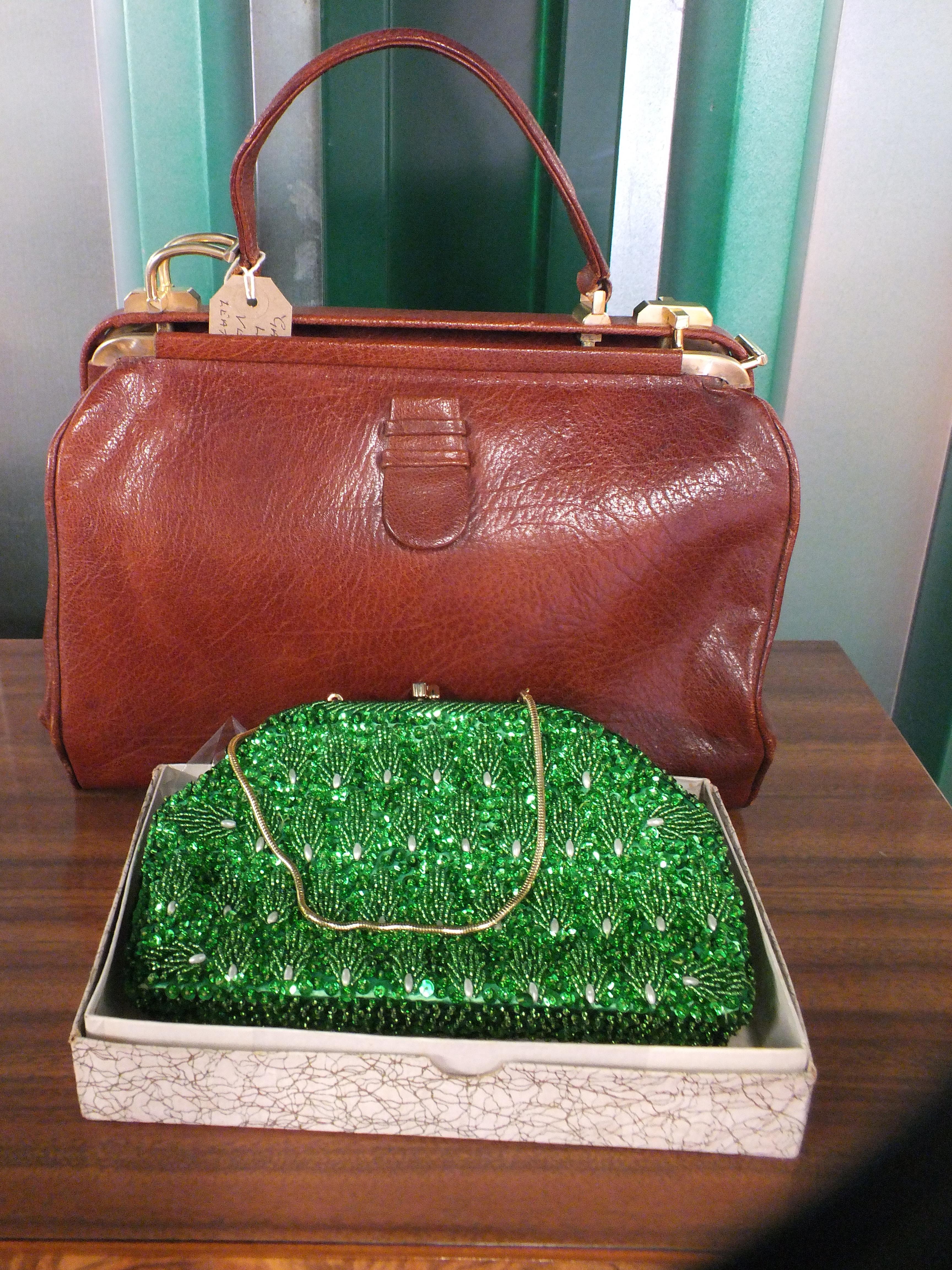 A brown leather handbag and beaded green evening purse