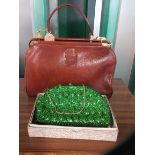 A brown leather handbag and beaded green evening purse