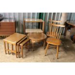 A collection of vintage wooden furniture including a nest of tables, two kitchen chairs,