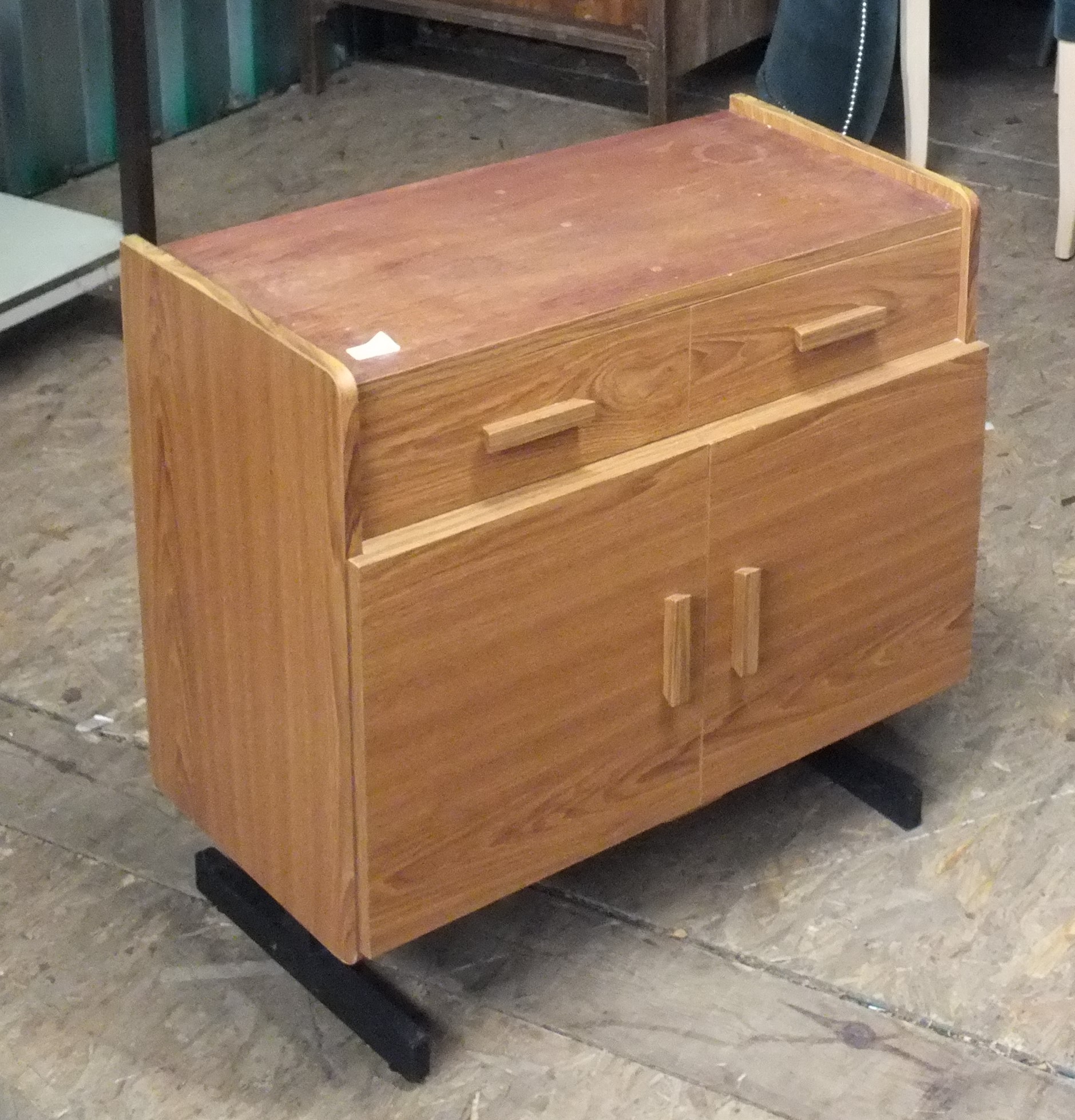 A small two drawer two door cupboard on black metal base