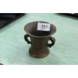 A small bronze mortar marked 1638, scrolling ornamentation and twin dolphin handles,