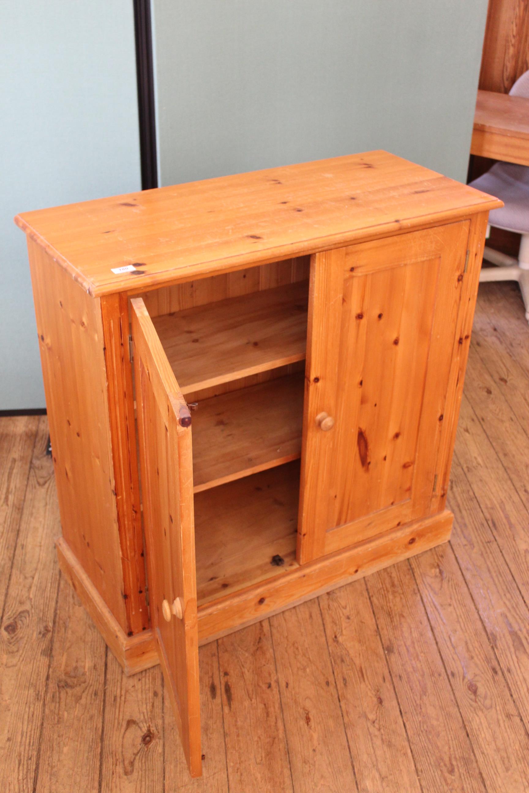 A pine two door cupboard with two shelves to interior