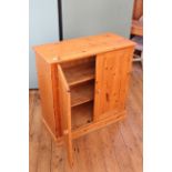 A pine two door cupboard with two shelves to interior