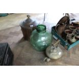 A copper coal or log bin together with an ornate brass kettle and a green glass terrarium