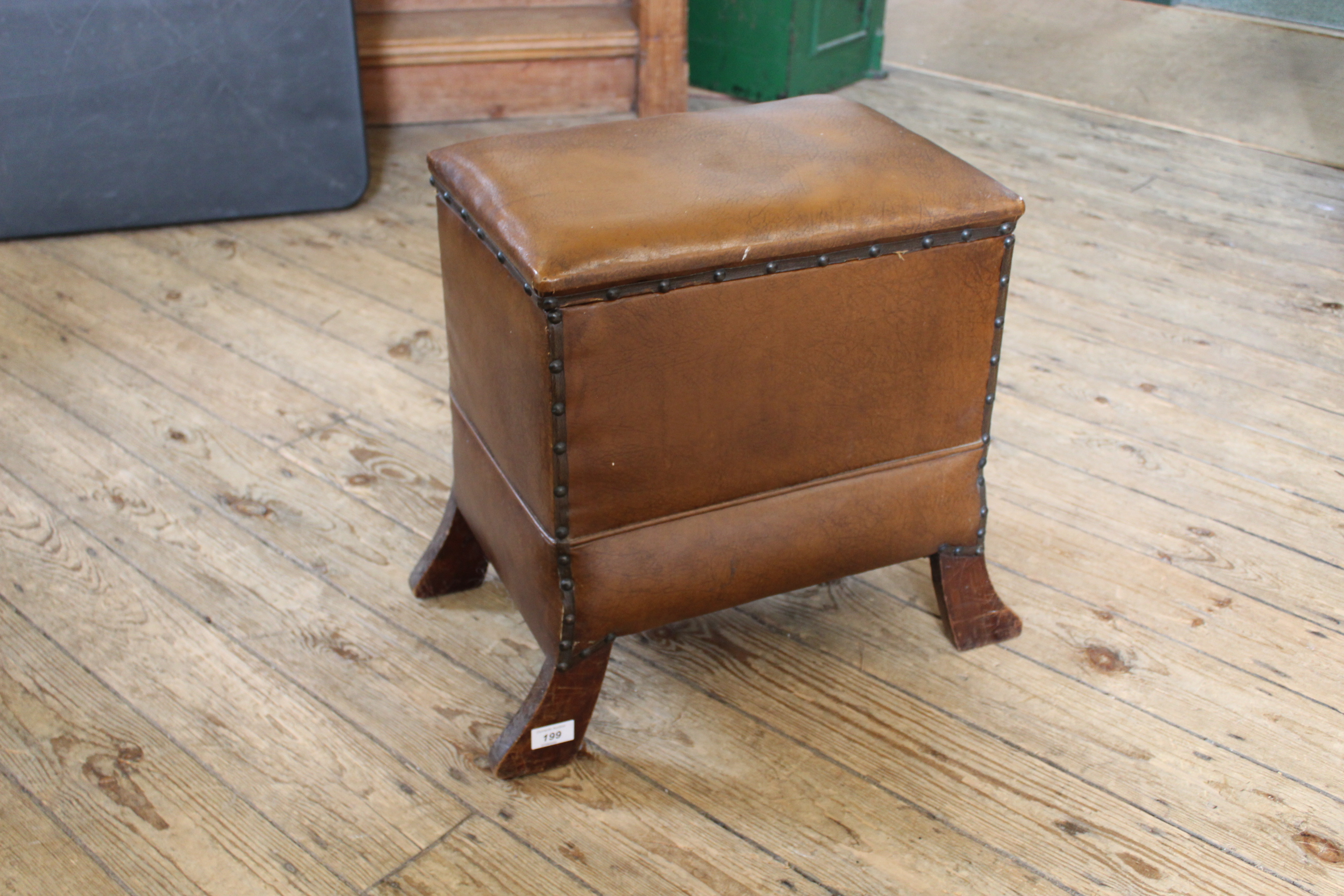 An Arts and Crafts style leatherette and oak lifting top stool