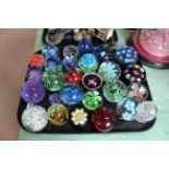 A tray of various size glass paperweights