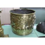 A decorative 19th Century embossed brass jardiniere or log bucket with lion mask ring handles,