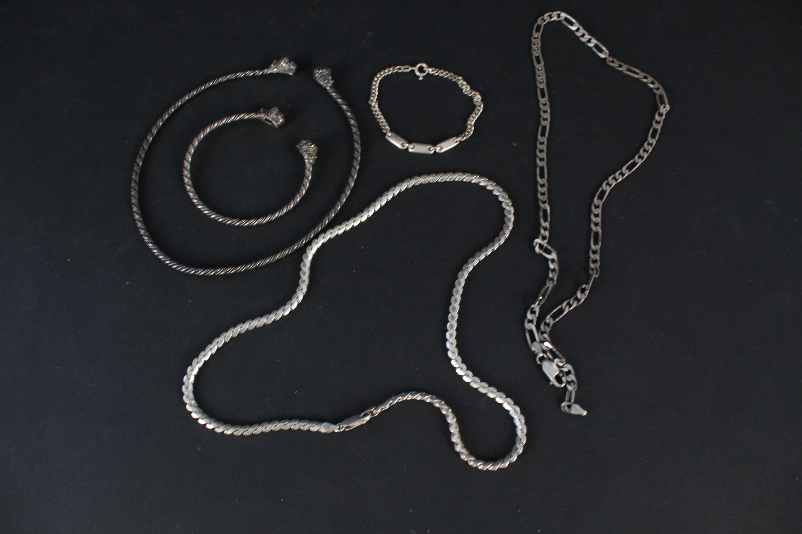 A matching white metal choker and bracelet set of twisted design with lion head terminals,