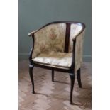 An Edwardian upholstered tub chair on cabriole legs