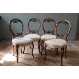 A set of four mid Victorian walnut balloon back chairs on cabriole legs,