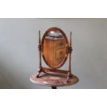 An Edwardian swing toilet mirror with scallop edge oval frame