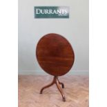 An early 19th Century mahogany circular top tripod table with flip top,