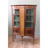 An Edwardian inlaid mahogany display cabinet on square tapered legs and bow fronted doors,