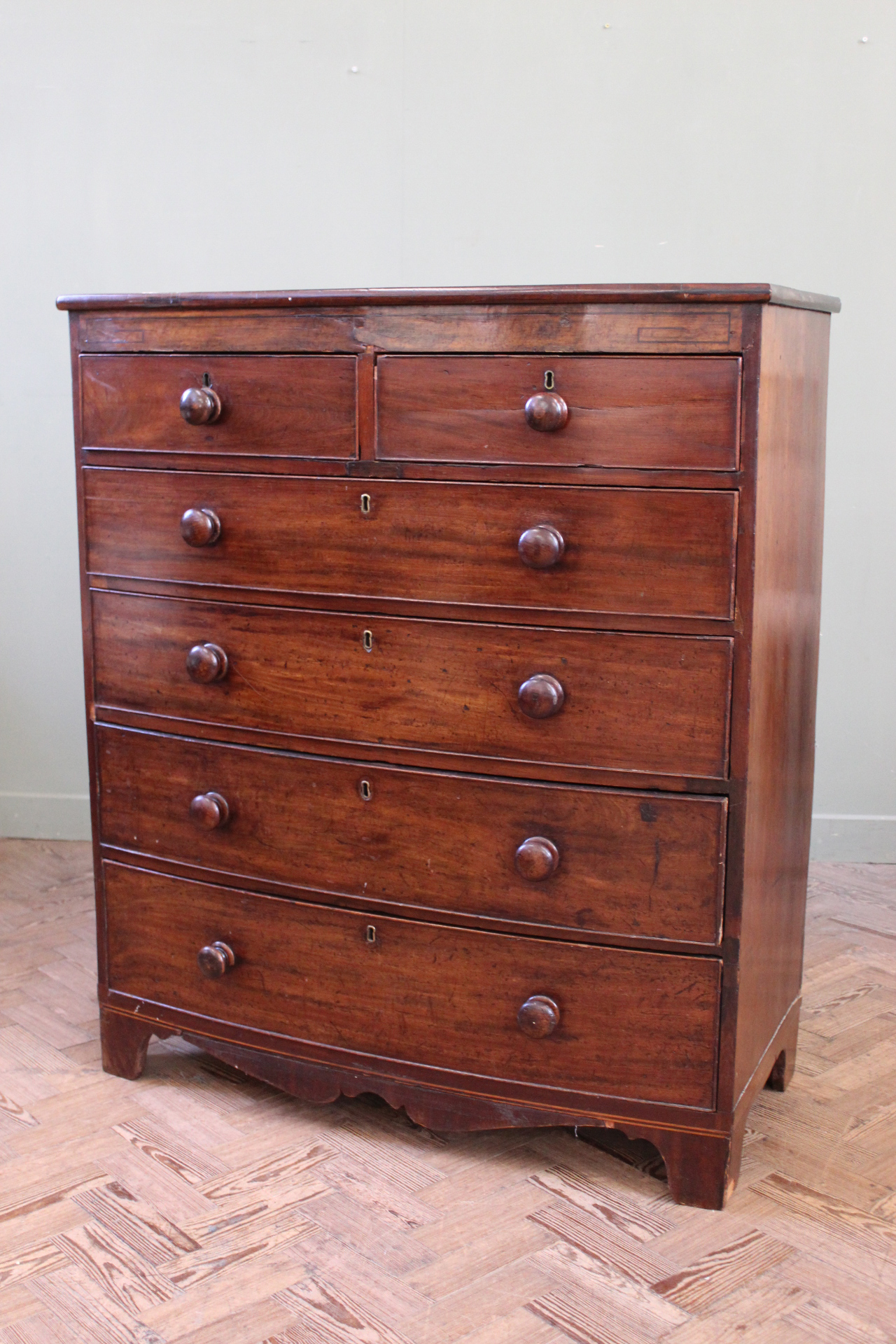 An early 19th Century mahogany chest of six drawers on shaped bracket and apron,