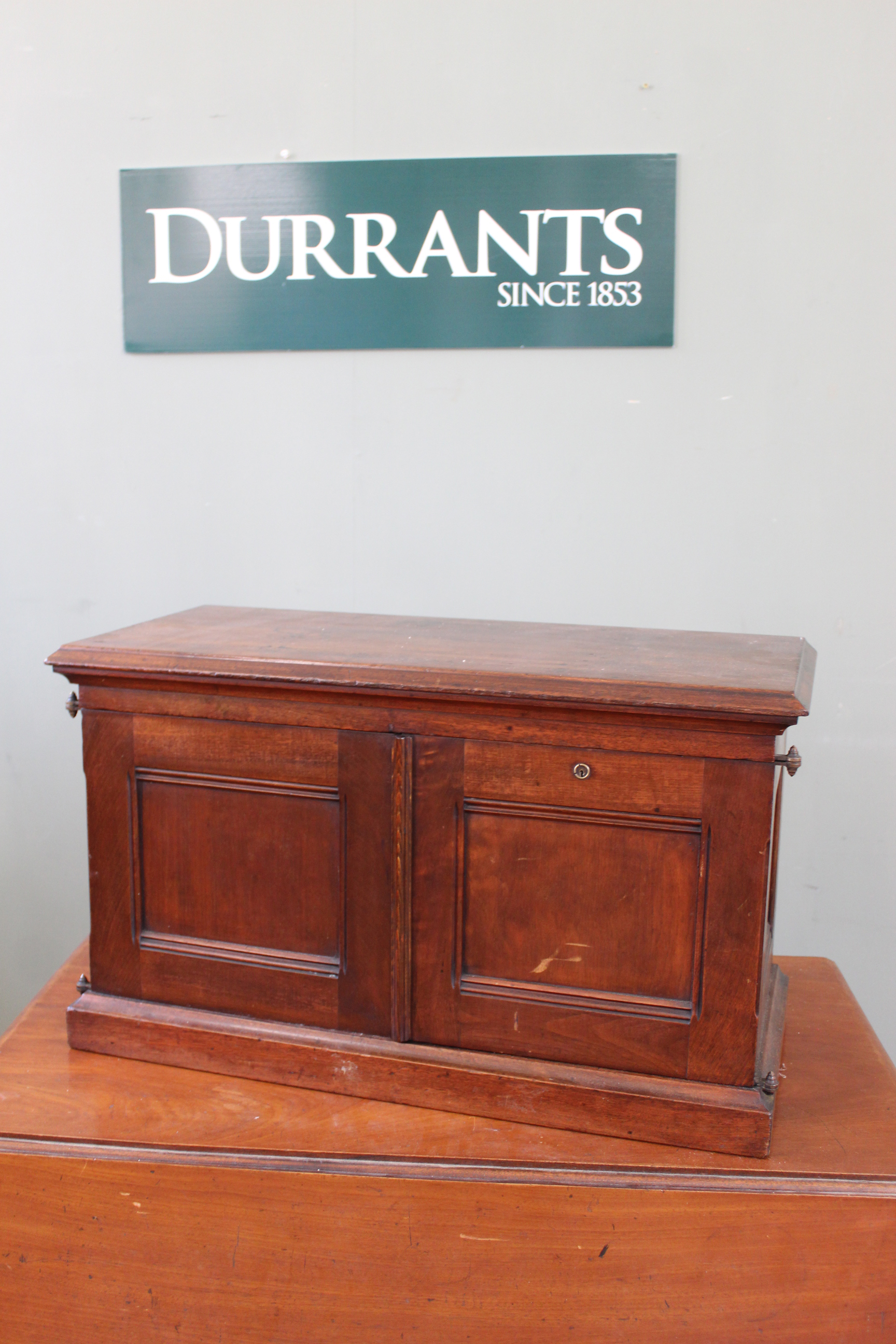 A late 19th Century mahogany two door desk top cabinet with shelved interior with three drawers,