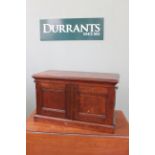 A late 19th Century mahogany two door desk top cabinet with shelved interior with three drawers,