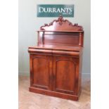 A mid 19th Century chiffonier with shaped back and shelf on turned supports,