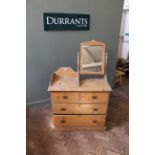 An Edwardian pine four drawer dressing chest with swing mirror