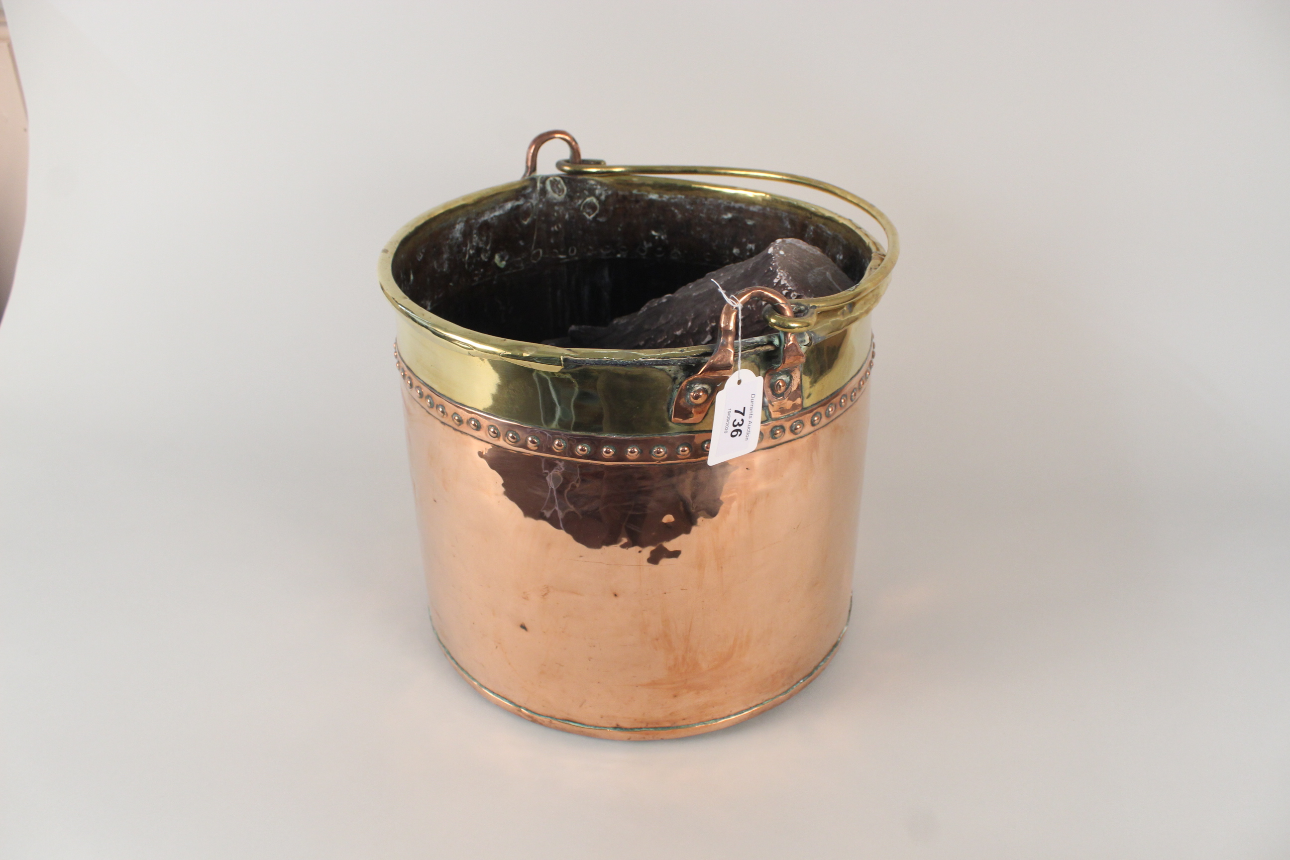 A Victorian copper and brass log/coal bin with faux logs