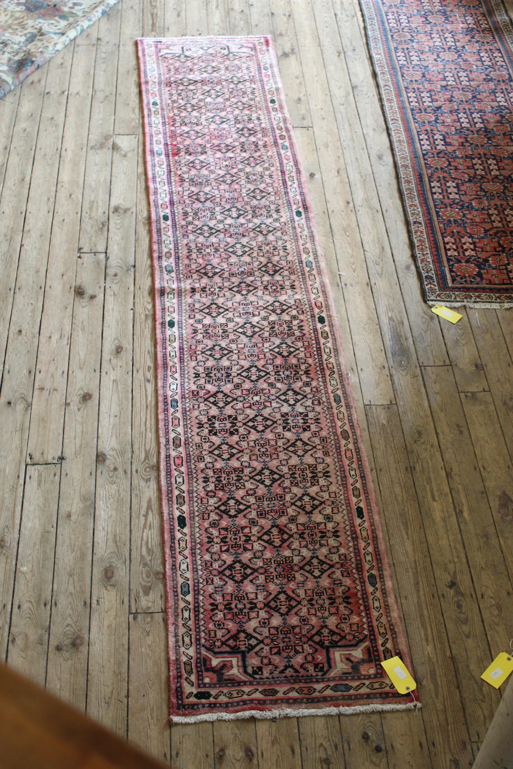 A Persian Hearti design runner, on a pink ground,