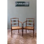 A pair of Edwardian satinwood armchairs of Sheraton design.