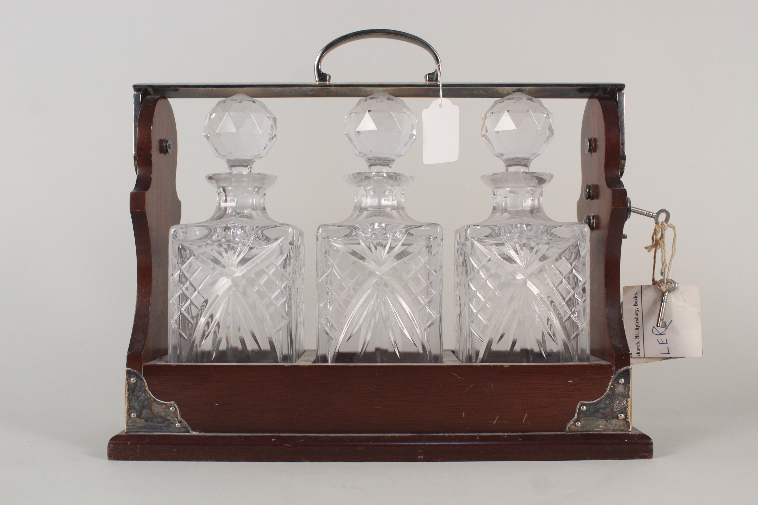 An oak and silver plated three cut glass decanter tantalus, marked PB&S with key,