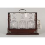 An oak and silver plated three cut glass decanter tantalus, marked PB&S with key,