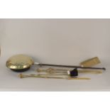 An early 19th Century brass and steel warming pan together with a set of brass fire irons and