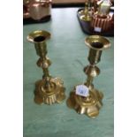 A pair of 18th Century seamed brass candlesticks with knopped stems and petal shaped bases,