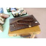 A leather attaché case with keys and a crocodile skin book cover