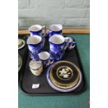 A tray with four large and two small Flow Blue jugs,