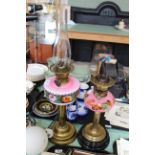 Two Victorian brass oil lamps with decorated pink glass reservoirs (one shade)