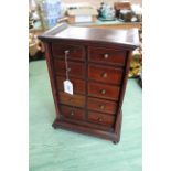 A late Victorian inlaid mahogany bank of ten small drawers with brass knob handles and bun feet,