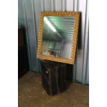 A gilt wall mirror plus a pine trunk